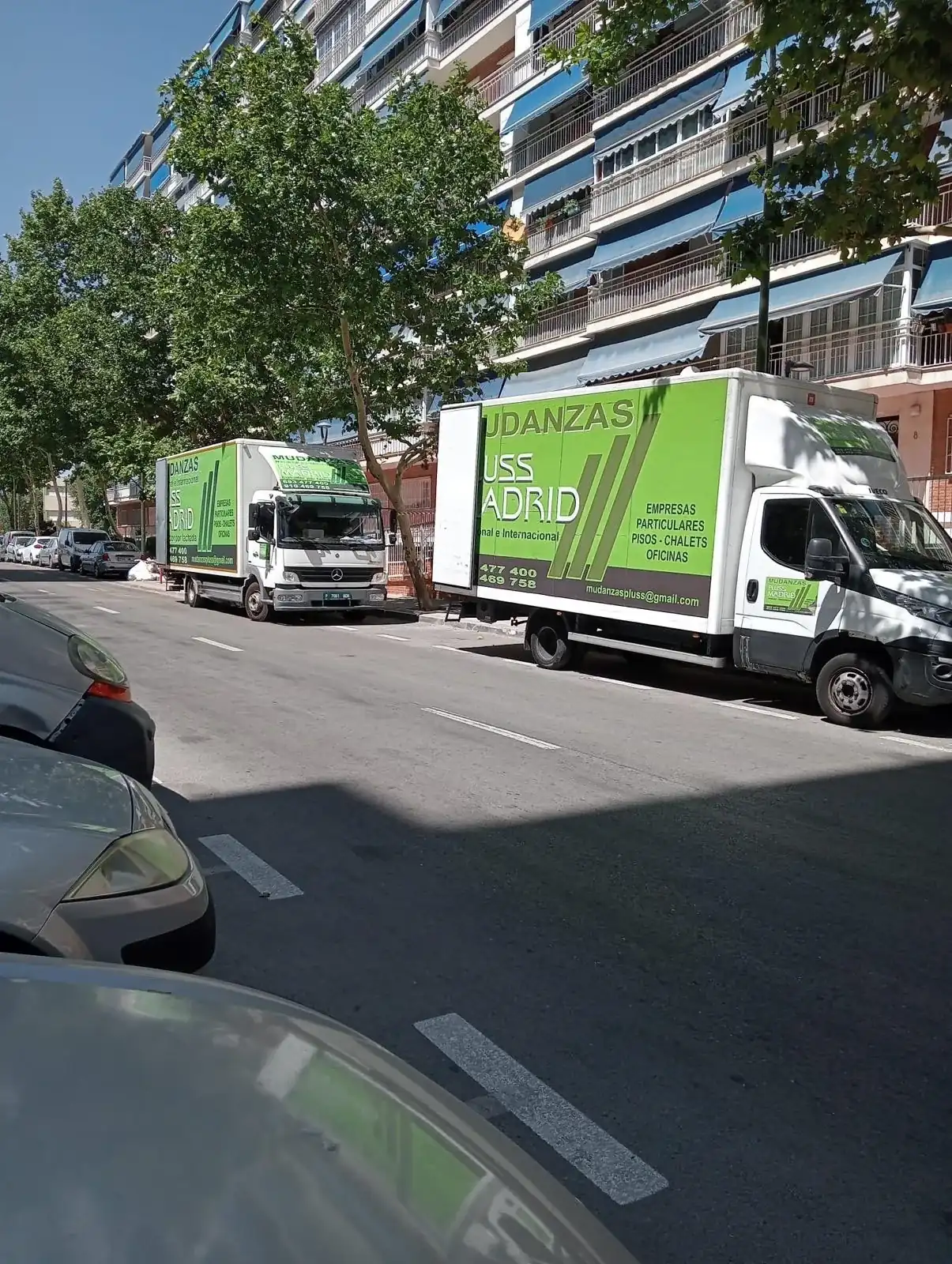 Furgonetas de Mudanzas Plus Siglo XXI aparcadas en una calle de Madrid