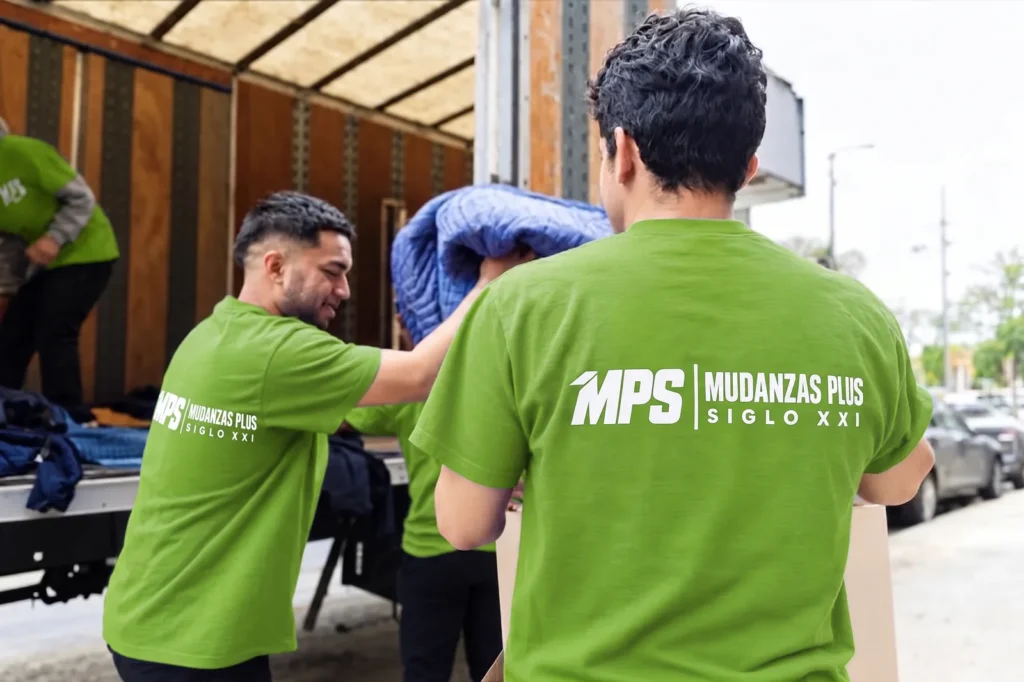 Equipo de Mudanzas Plus Siglo XXI cargando mantas y bultos en el camión
